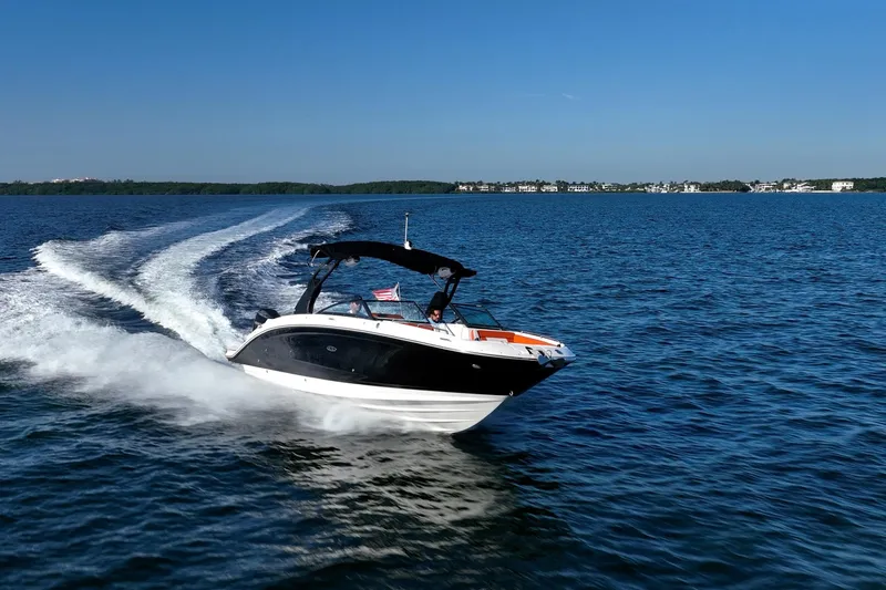 Slide: The Image of 2019 Sea Ray SDX 290 Outboard cruising on open water under clear blue skies. - 72