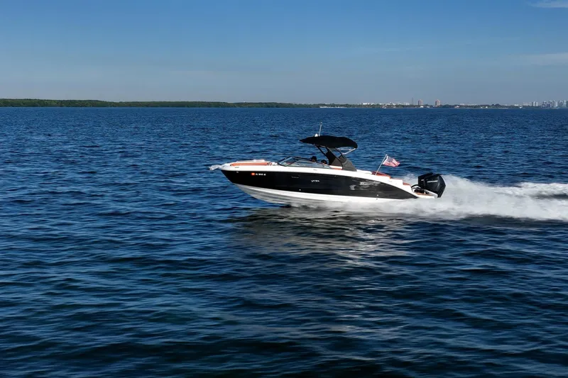 Slide: The Image of 2019 Sea Ray SDX 290 Outboard cruising on open water under clear blue skies. - 76