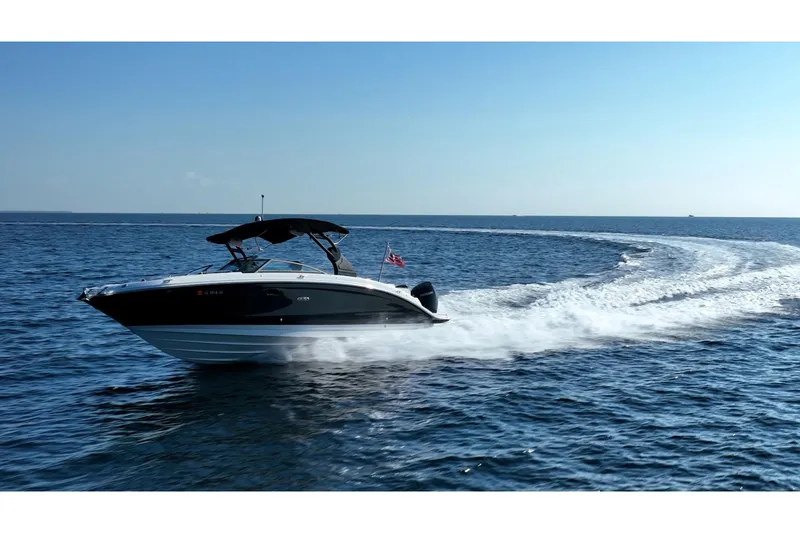 Slide: The Image of 2019 Sea Ray SDX 290 Outboard cruising on open water under clear blue sky. - 78