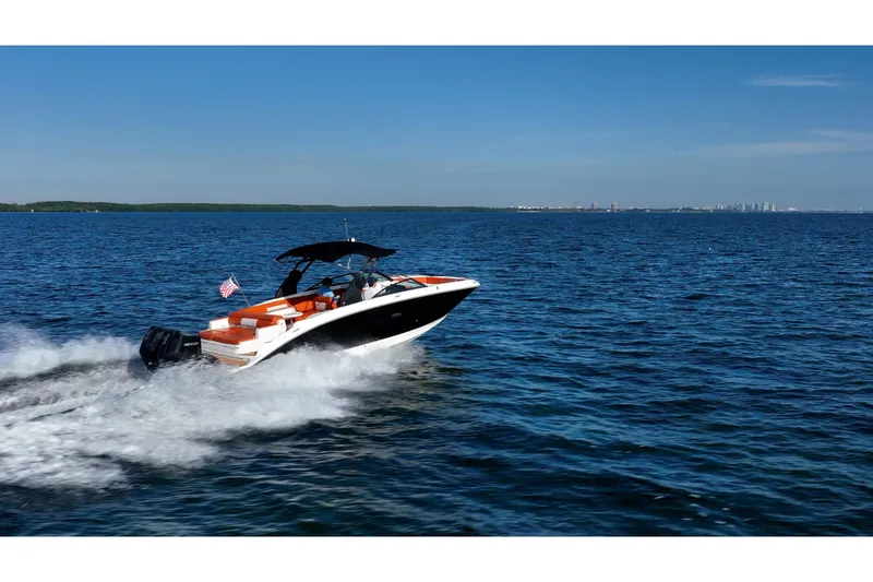 Slide: The Image of 2019 Sea Ray SDX 290 Outboard cruising on open water under clear blue skies. - 79