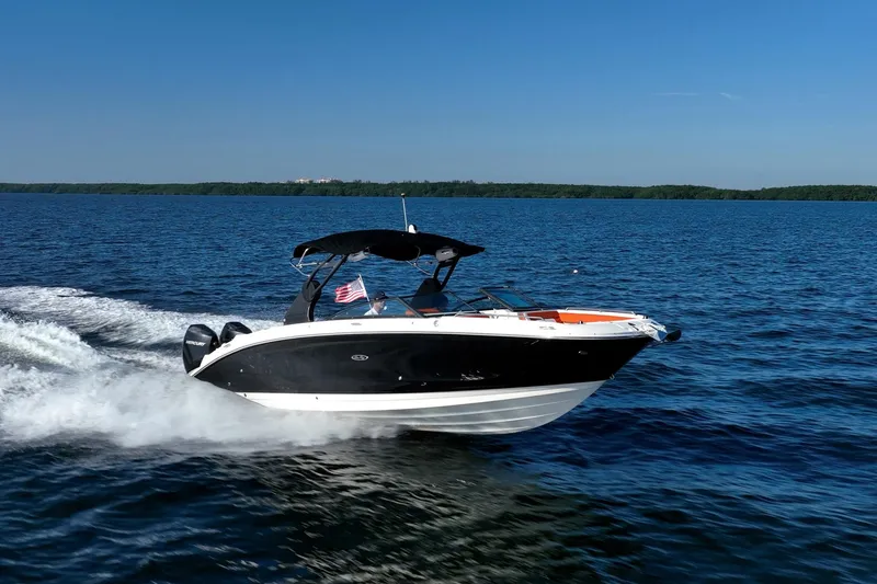 Slide: The Image of 2019 Sea Ray SDX 290 Outboard cruising on open water under clear blue sky. - 82
