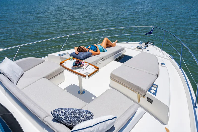 Slide: The Image of 2026 Riviera 5600 Sport Yacht Platinum Edition with sunbathing area on deck. - 2