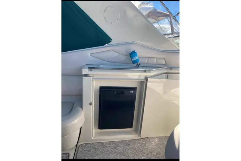 Slide: The Image of 1997 Regal Commodore 3260 boat interior with mini fridge and seating area. - 12