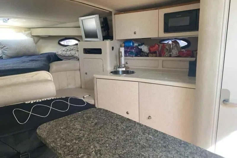 Slide: The Image of 1997 Regal Commodore 3260 cabin interior with kitchenette and sleeping area. - 13