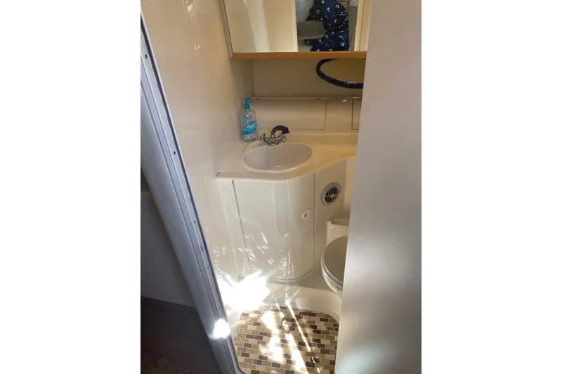 Slide: The Image of Bathroom interior of 1997 Regal Commodore 320 boat with sink and mirror. - 16