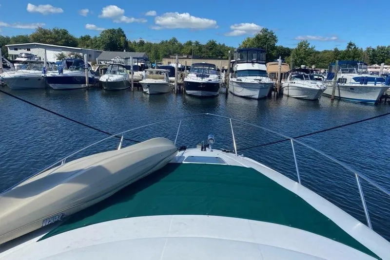 Slide: The Image of 1997 Regal Commodore 3260 yacht docked at marina with other boats under blue sky. - 2