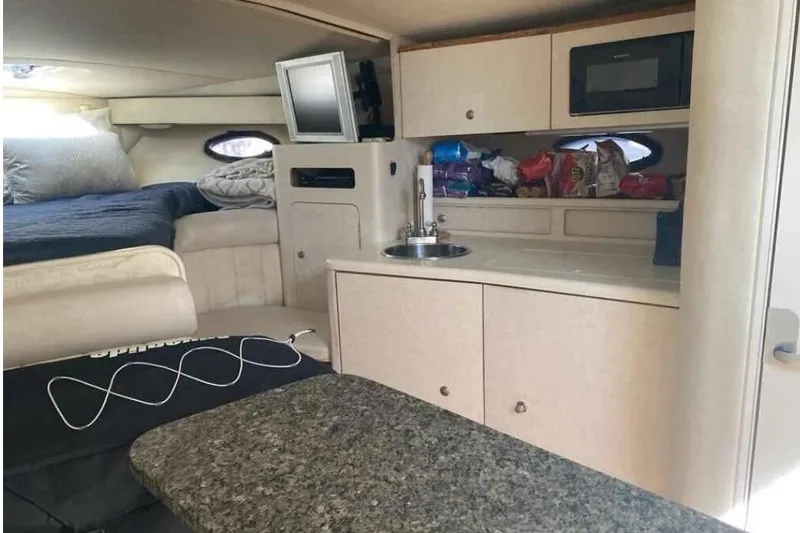 Slide: The Image of Interior of a 1997 Regal Commodore 3260 boat with kitchenette and sleeping area. - 8