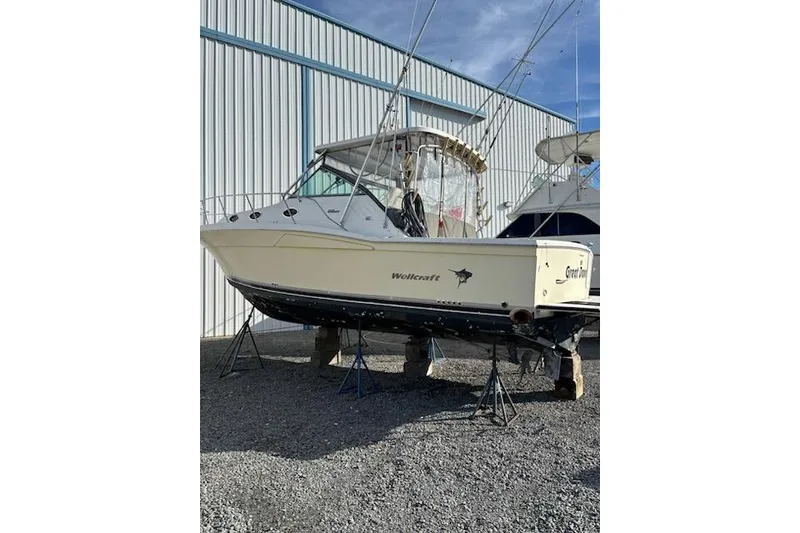 The Image of 2003 Wellcraft 3300 Coastal boat on stands, outside storage facility. - 0