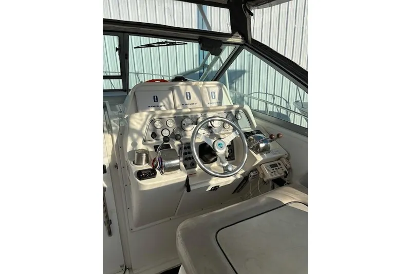 Slide: The Image of 2003 Wellcraft 3300 Coastal boat cockpit with steering wheel and control panel. - 3