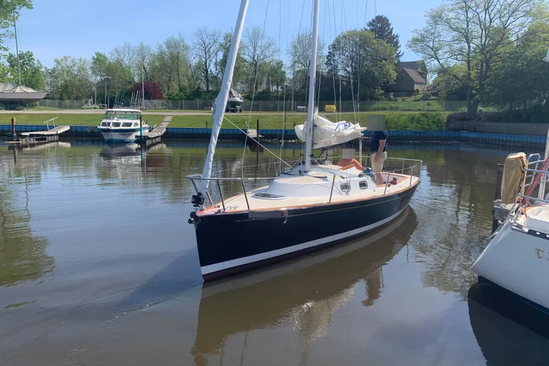 Slide: The Image of 2021 Tartan Fantail sailboat docked in a serene marina setting. - 2