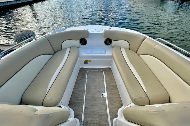 Slide: The Image of 2022 NauticStar 223 DC boat interior with beige seating and water view. - 15