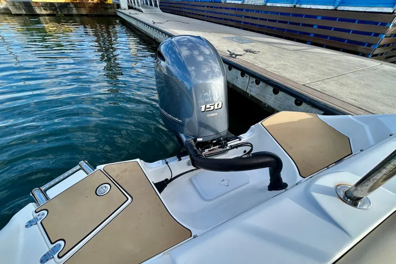 Slide: The Image of 2022 NauticStar 223 DC boat with Yamaha 150 engine docked by the water. - 16