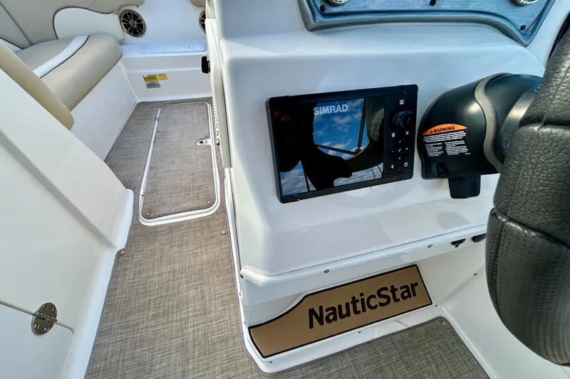 Slide: The Image of 2022 NauticStar 223 DC boat interior with Simrad navigation system and comfortable seating. - 18