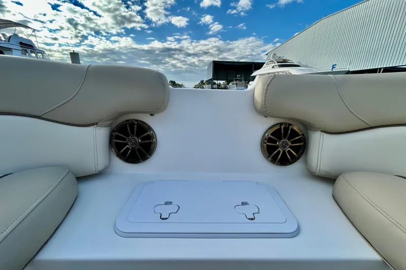 Slide: The Image of 2022 NauticStar 223 DC boat interior with beige seating and built-in speakers. - 19