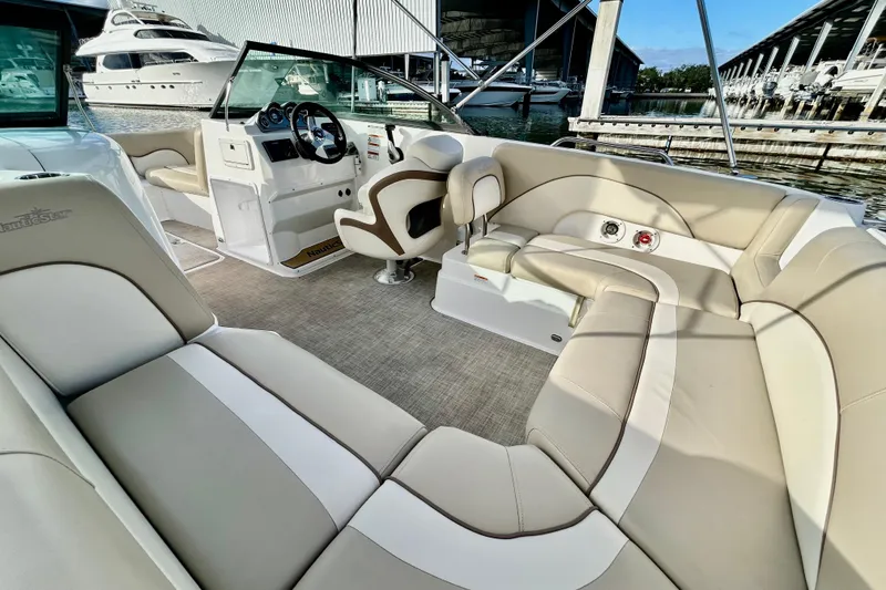 Slide: The Image of 2022 NauticStar 223 DC boat interior with beige seating and steering console. - 3