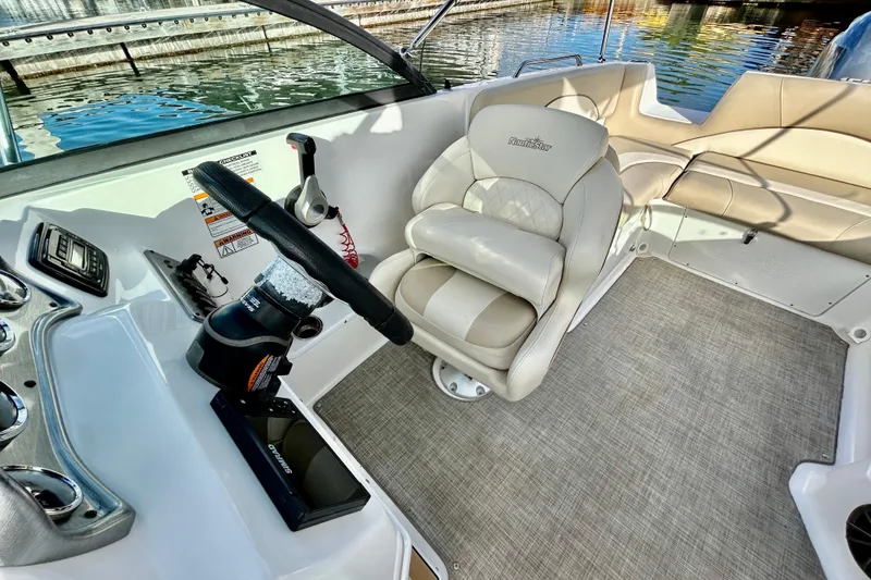 Slide: The Image of 2022 NauticStar 223 DC boat interior with steering wheel and seating. - 5