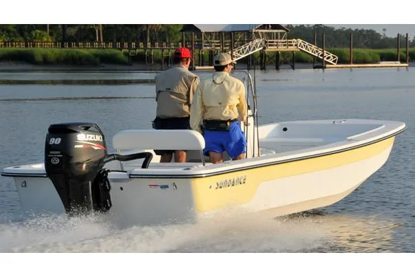 Slide: The Image of Manufacturer Provided Image: 2025 Sundance B20CCR boat cruising on a calm river with two passengers. - 5