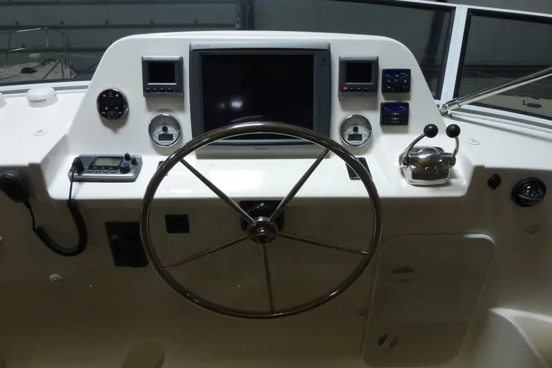 Slide: The Image of Control panel of a 2009 Maine Cat P-47 boat with steering wheel and navigation instruments. - 12