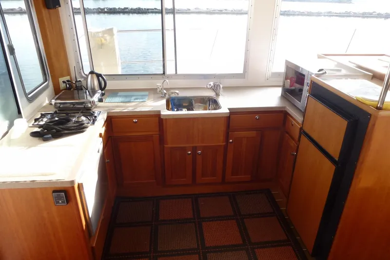 Slide: The Image of Interior of 2009 Maine Cat P-47 kitchen with wooden cabinets and appliances. - 15