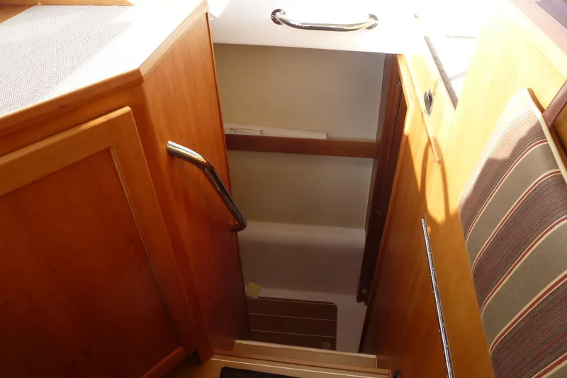 Slide: The Image of Interior stairs of 2009 Maine Cat P-47 boat with wooden finish and striped cushion. - 20