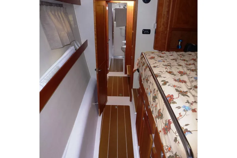 Slide: The Image of Interior of 2009 Maine Cat P-47, featuring a cozy cabin with floral bedding. - 22