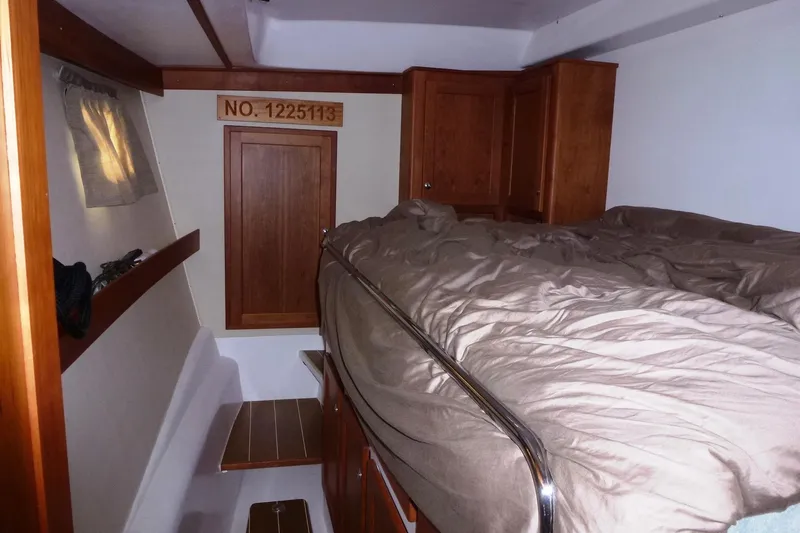 Slide: The Image of Interior cabin of 2009 Maine Cat P-47 with bed and wooden cabinetry. - 25