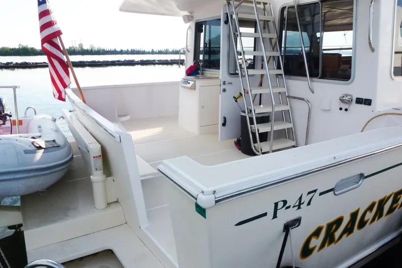 Slide: The Image of Maine Cat P-47 boat, 2009 model, docked with American flag and inflatable dinghy. - 5