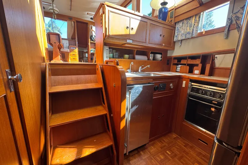 Slide: The Image of 1990 Grand Banks 46 Classic yacht kitchen with wood cabinetry and stainless steel appliances. - 22