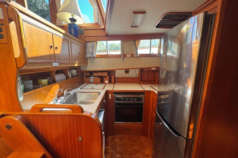 Slide: The Image of Interior of 1990 Grand Banks 46 Classic yacht kitchen with wood cabinetry and stainless steel appliances. - 24