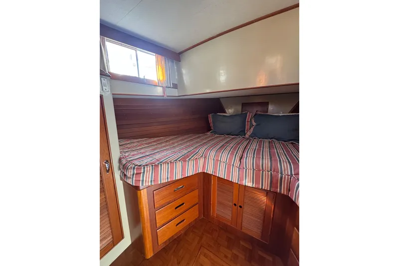 Slide: The Image of Cozy cabin interior of 1990 Grand Banks 46 Classic yacht with wood paneling and striped bedding. - 33