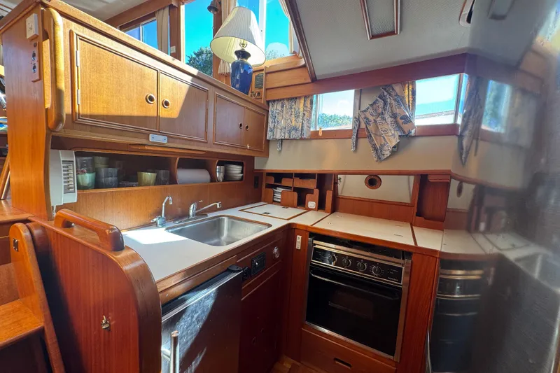 Slide: The Image of 1990 Grand Banks 46 Classic yacht docked by lush greenery. - 4