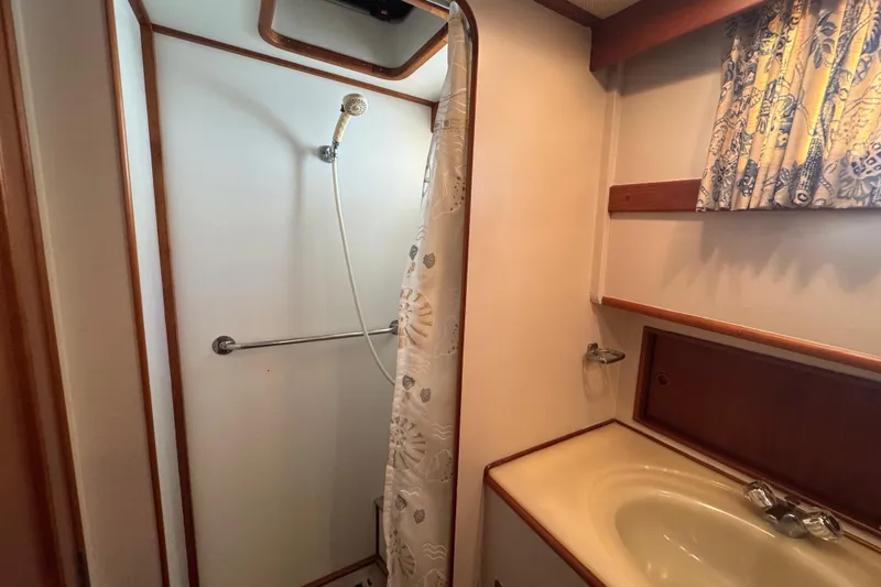 Slide: The Image of Shower area in 1990 Grand Banks 46 Classic yacht with curtain and wooden accents. - 40