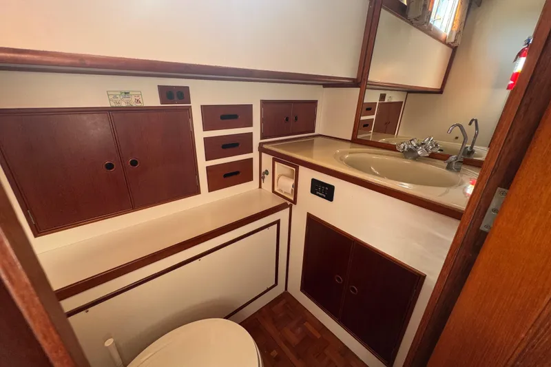 Slide: The Image of Cozy bedroom interior of 1990 Grand Banks 46 Classic yacht with wooden accents and soft lighting. - 46