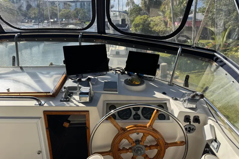 Slide: The Image of 1990 Grand Banks 46 Classic yacht interior with wooden trim and window curtain. - 50