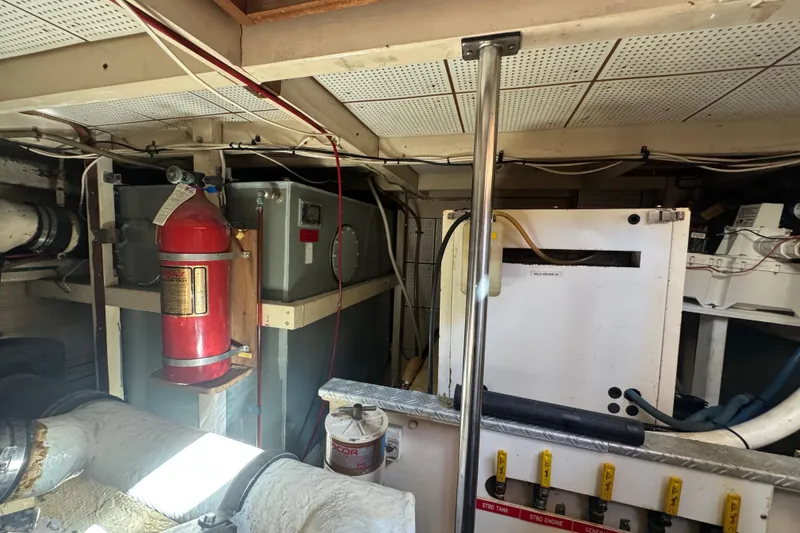 Slide: The Image of Engine room of 1990 Grand Banks 46 Classic with fire extinguisher and mechanical components. - 58