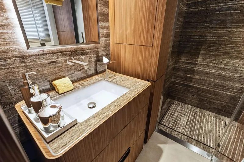 Slide: The Image of Luxurious bathroom with wooden cabinetry, modern sink, and elegant stone shower in Custom Line 120 yacht. - 114