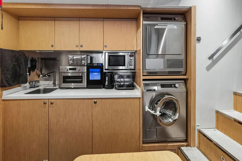 Slide: The Image of Compact yacht kitchen with modern appliances, washer, and dryer, Custom Line 120, 2018 model. - 119