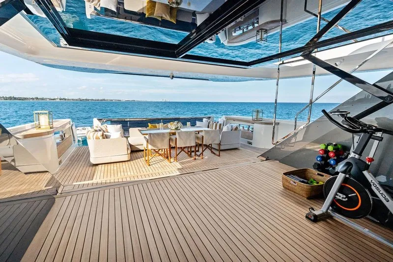 Slide: The Image of Luxurious 2018 Custom Line 120 yacht deck with seating, exercise bike, and ocean view. - 38
