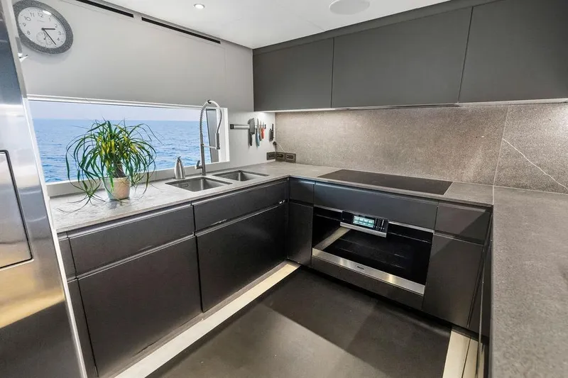 Slide: The Image of Modern yacht kitchen with sleek design, ocean view, and stainless steel appliances. Custom Line 120, 2018. - 65