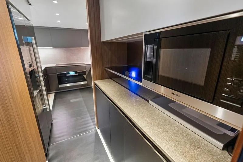 Slide: The Image of Modern kitchen interior with sleek appliances, featuring a Miele microwave, in a 2018 Custom Line 120 yacht. - 68