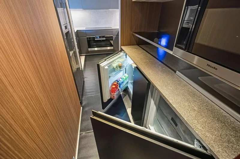 Slide: The Image of Modern kitchen with open fridge, sleek appliances, and wood paneling in a Custom Line 120 yacht. - 69