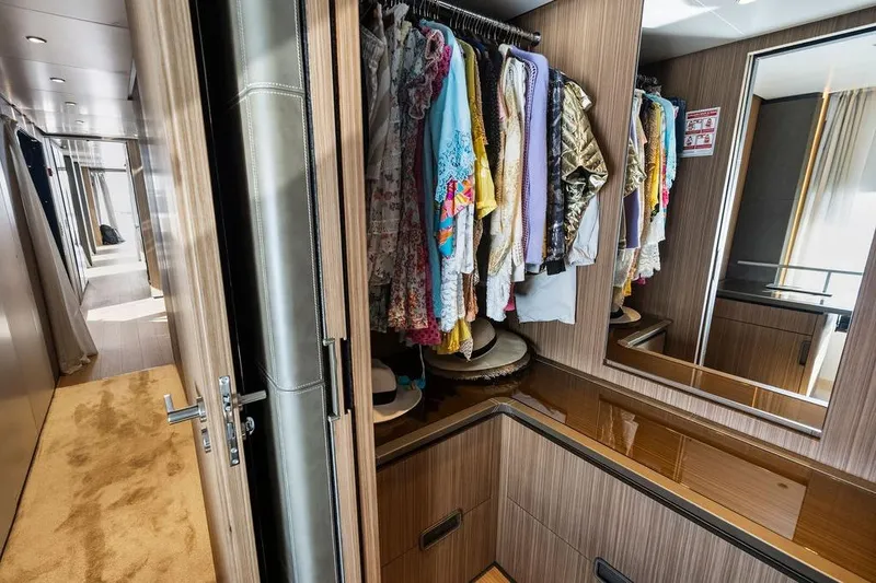 Slide: The Image of Luxurious yacht interior with a wooden wardrobe, colorful clothes, and a hallway view. - 87
