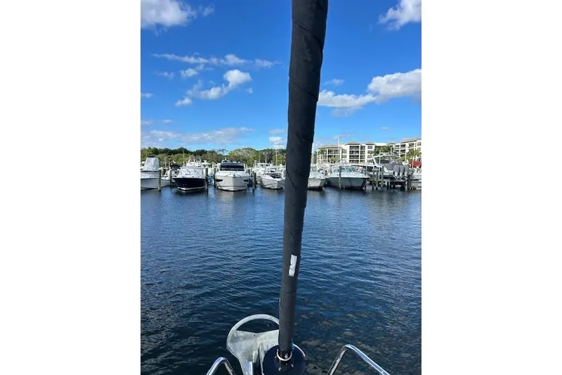 Slide: The Image of 2013 Beneteau Sense 46 sailboat docked in marina under clear blue sky. - 2