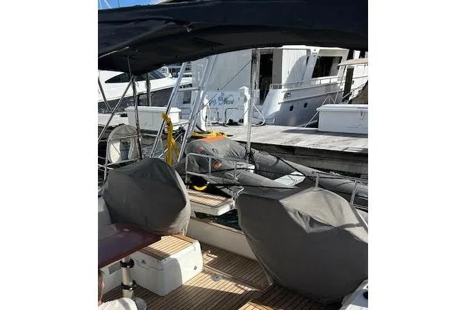 Slide: The Image of 2013 Beneteau Sense 46 sailboat docked in a marina under a clear blue sky. - 6