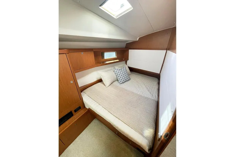 Slide: The Image of Cozy cabin interior of 2013 Beneteau Sense 46 yacht with wooden finish and bedding. - 68