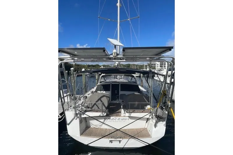 Slide: The Image of 2013 Beneteau Sense 46 yacht docked, featuring solar panels and spacious deck. - 76