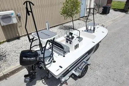 Slide: The Image of 2026 Spyder FX17 Flicker boat with Suzuki engine on trailer, parked outdoors. - 9