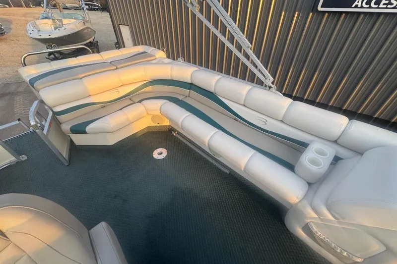 Slide: The Image of 2002 Bennington 2550RL pontoon boat interior with cushioned seating and cup holders. - 12