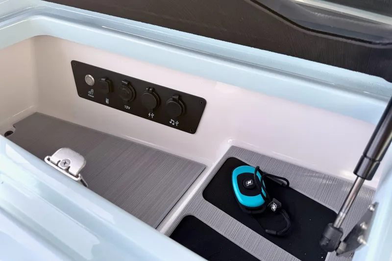 Slide: The Image of 2026 Nautique Super Air Nautique G21 storage compartment with control panel and device. - 21