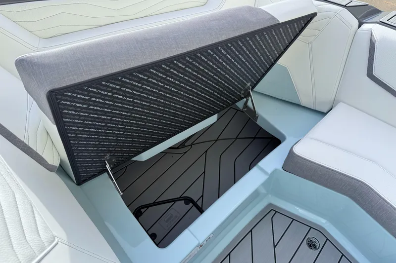 Slide: The Image of 2026 Nautique Super Air Nautique G21 interior storage compartment with open seat cushion. - 23